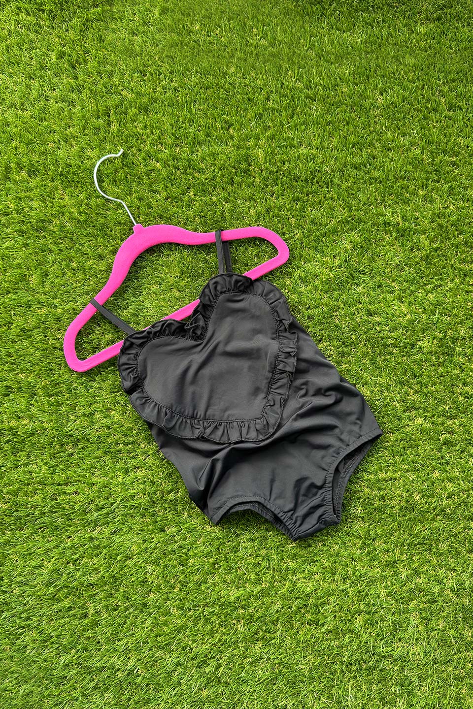 Heart-Shaped Swimwear for little girls and toddlers in black colorblock with ruffles and sleeveless. front photo flat lay
