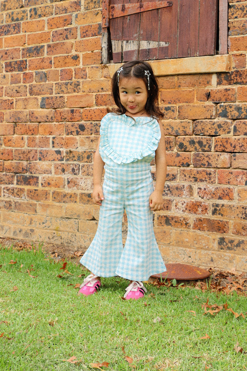 Get ready to fall in love with these Blue Gingham heart shape overalls! Made for little girls, these overalls feature a flared pant leg for added style and comfort. Perfect for any occasion, your little one will look adorable in these playful and unique overalls!. The flare pants add a playful touch to this charming piece. Your little one will surely steal the show in this sweet and stylish outfit. Lifestyle front